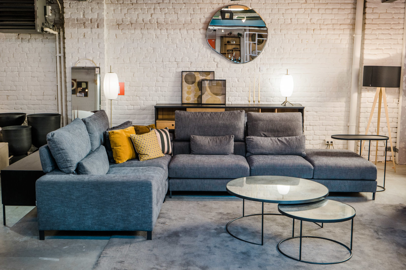 Un salon avec un canapé gris et une table basse. Le Canapé Horizon ajoute une touche d'élégance à l'espace, tandis que le Canapé Horizon offre des sièges confortables aux invités.