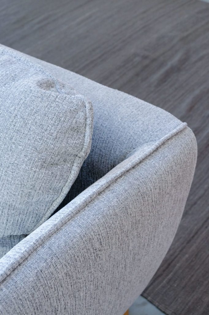 Un gros plan d'un Canapé Stella sur un parquet.