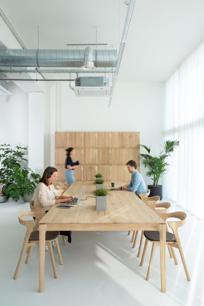 Une salle de réunion d'affaires avec une table et des chaises en bois.