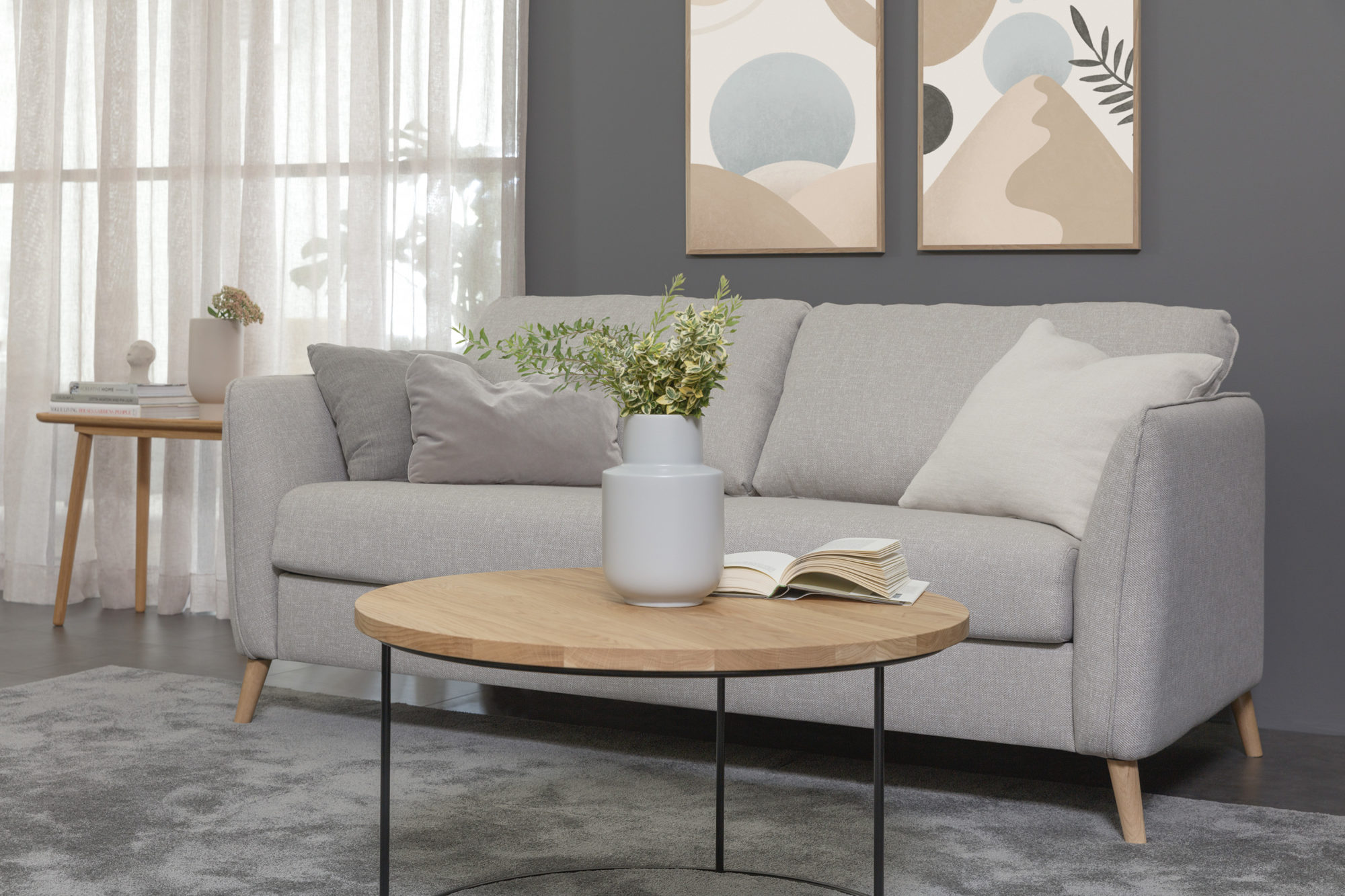 Canape convertible Lucy en tissu carlina gris-beigede la marque Sits avec coussin sur le canape tableau au mur et table basse dans un salon
