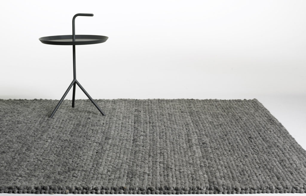 Un tapis gris avec un support en métal sur le dessus.