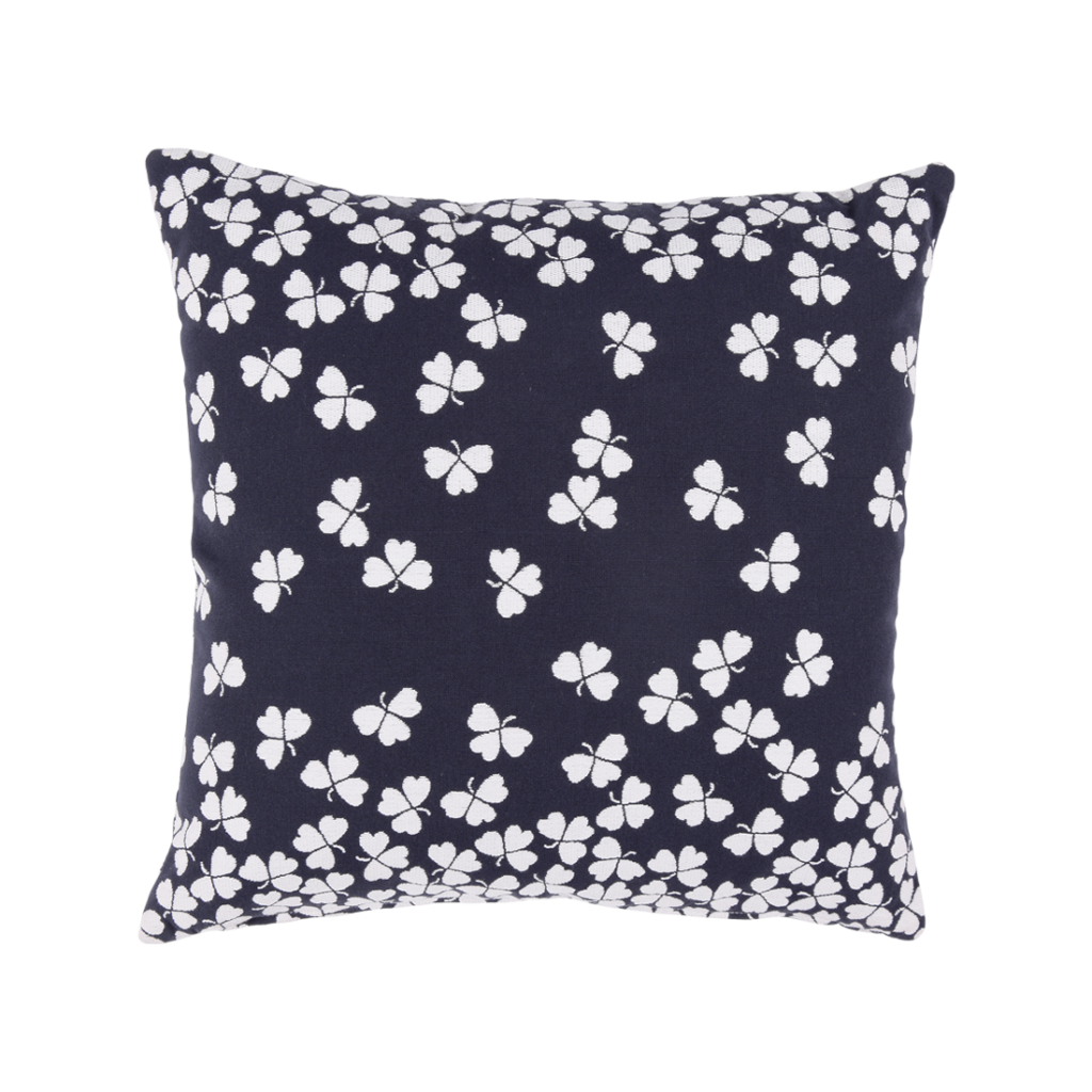 Un oreiller bleu marine avec des fleurs blanches dessus.