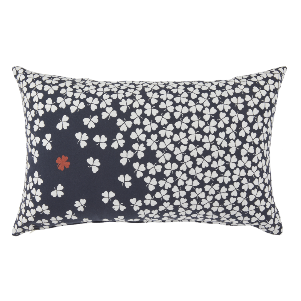 Un coussin avec un motif de fleurs blanches sur fond marine.