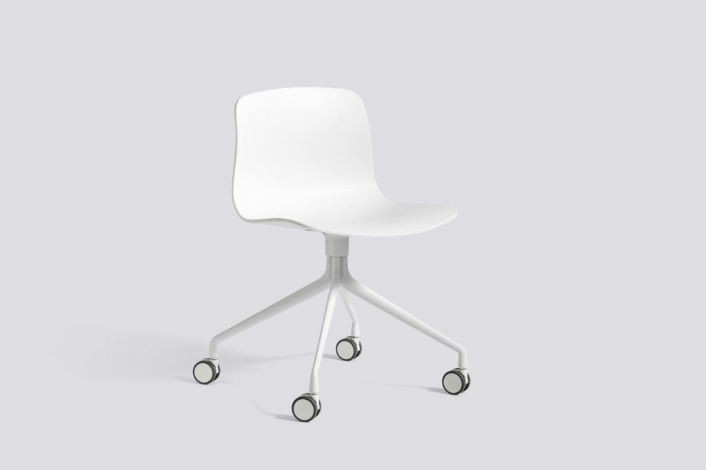 Une chaise blanche à roulettes sur fond gris.