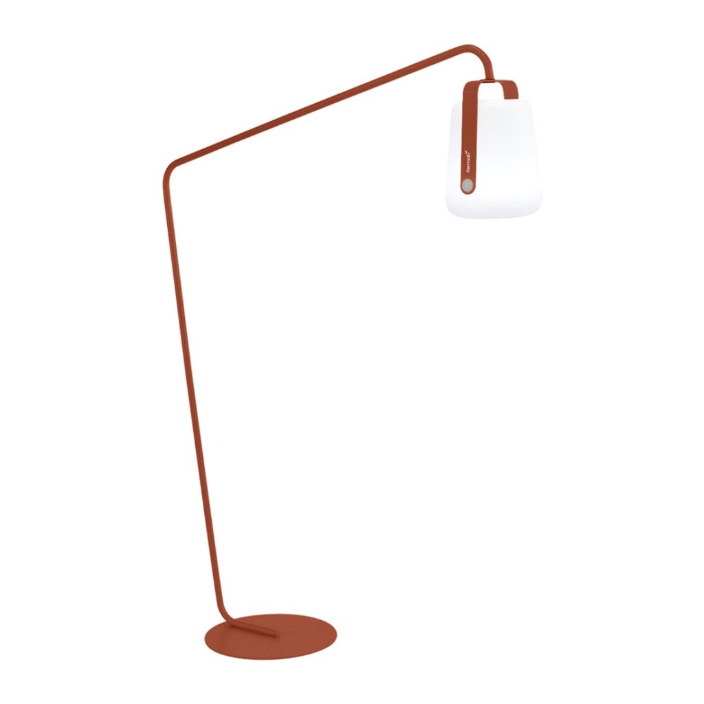 Un lampadaire orange avec un abat-jour blanc.