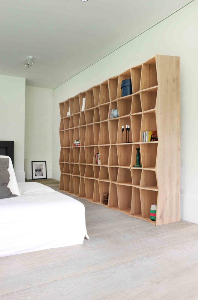 Une chambre avec un lit et des étagères.