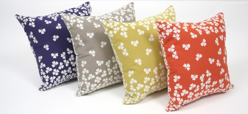 Quatre coussins colorés avec un motif floral dessus.