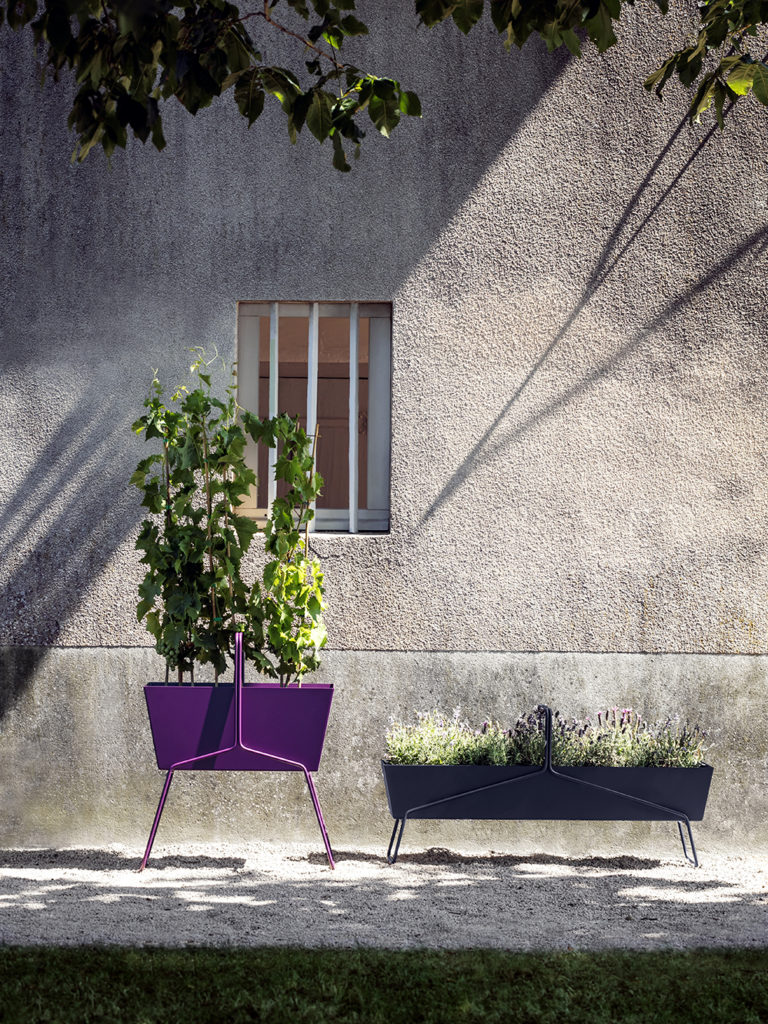Deux jardinières violettes devant un immeuble.