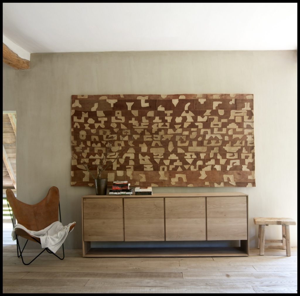 Un séjour avec un buffet en bois et une chaise.