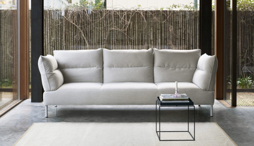 Un canapé blanc est assis devant une porte vitrée.