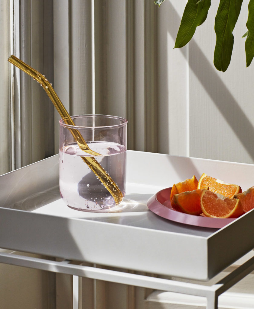 Un plateau avec un verre d'eau et des oranges dessus.