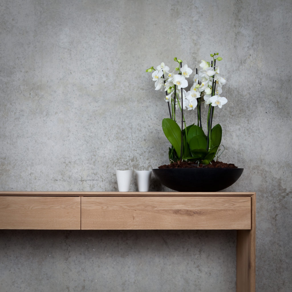 Une table en bois avec un vase de fleurs dessus.