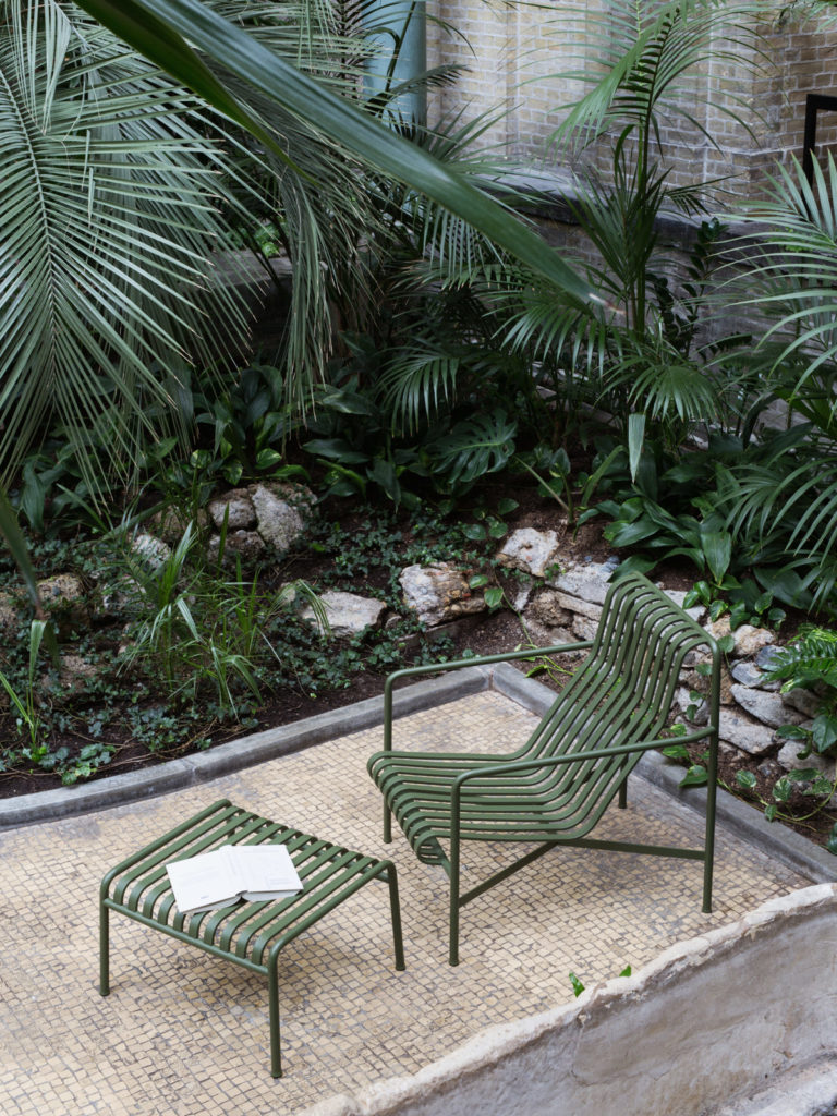 Une chaise verte au milieu d'un jardin.