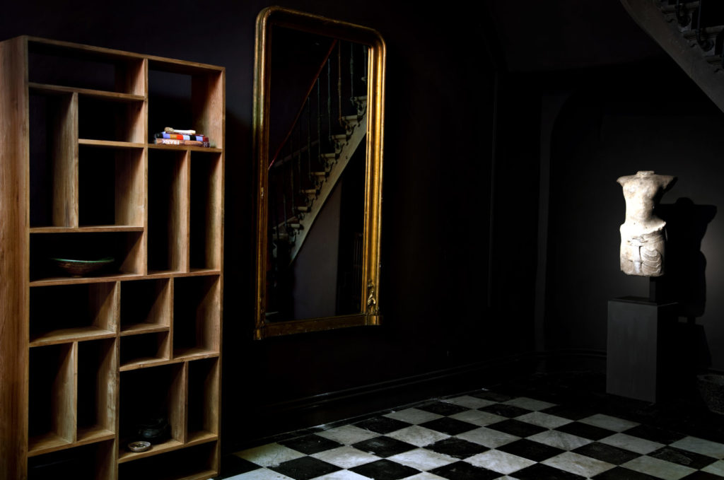 Un sol en damier noir et blanc dans une pièce avec un mannequin.