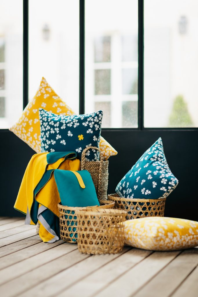 Un groupe d'oreillers jaunes et bleus sur un parquet.
