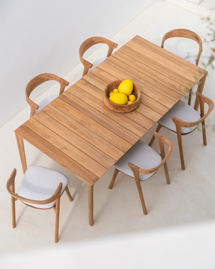 Une table avec des chaises et un bol de citrons.