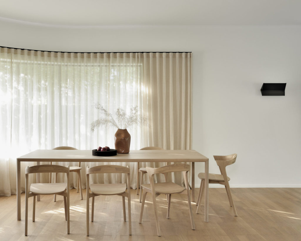 Une salle à manger aérée avec une table Air en chêne naturel et des chaises en chêne.