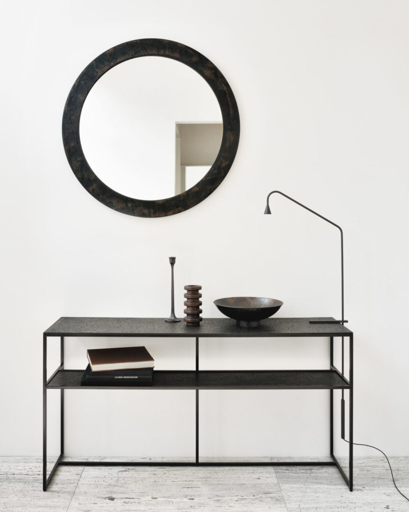 Une table console Pentagone avec un miroir au-dessus.
