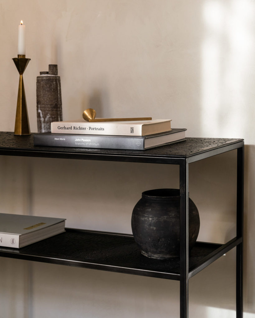 Une console Pentagone noire avec des livres dessus.