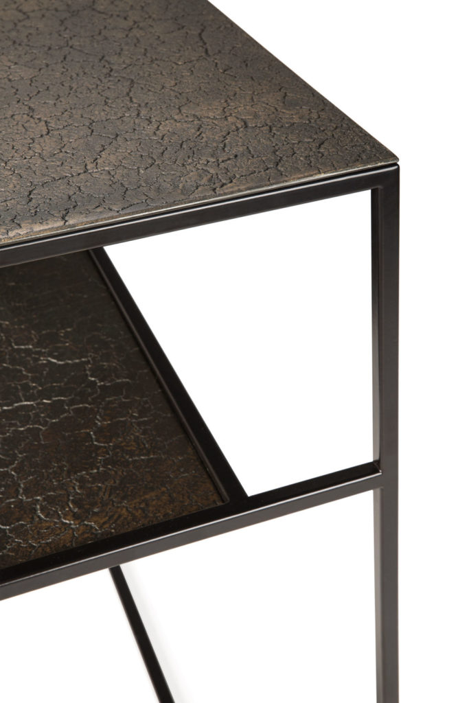 Une table d'appoint avec une structure en métal noir et un plateau en verre. Cette console moderne Pentagone présente des lignes épurées et un design élégant, parfait pour tout espace contemporain.