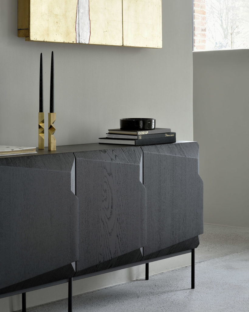 Buffet Stairs en chêne noir teinté vernis et pieds en metal noir dans une maison avec bougies sur le buffet et tableau au mur