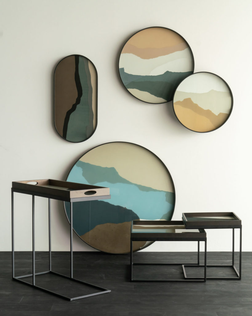 Un groupe de peintures encadrées sur un mur, présentant une variété de styles artistiques rendus sur des plaques Plateau ovale/oblong en verre Graphite Wabi Sabi Medium.