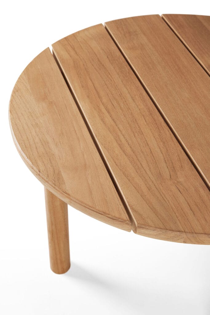 Une table basse de jardin Quatro en bois ronde sur un fond blanc.