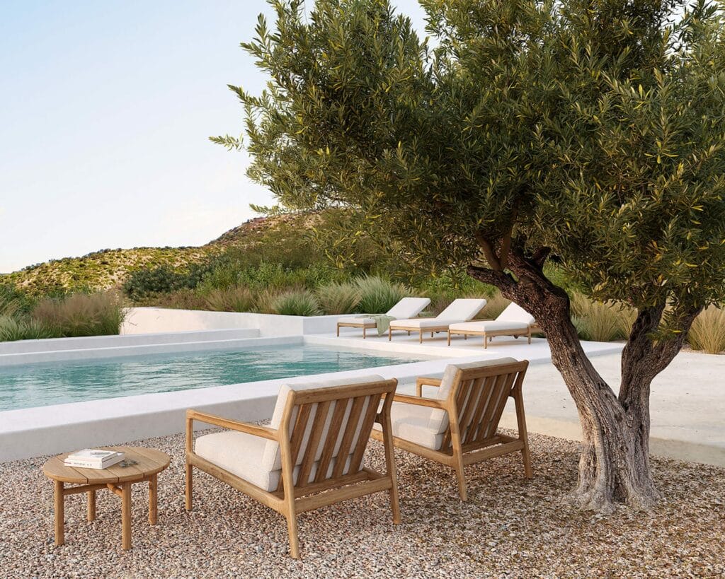 Une table d'appoint de jardin Quatro en teck naturel placée à côté d'une piscine.