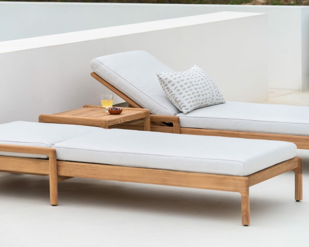 Une chaise longue en teck avec un Coussin pour chaise longue Jack et des oreillers.