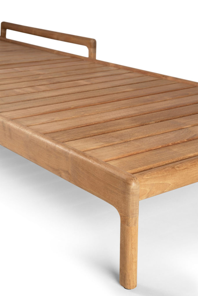 Un lit de repos en bois, également connu sous le nom de Chaise longue Jack en teck, sur fond blanc.