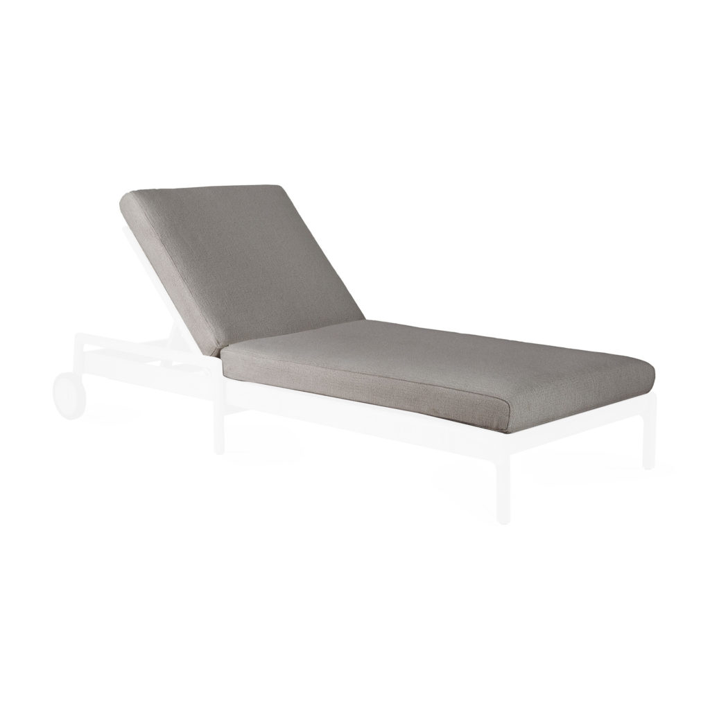 Une chaise longue Jack en teck avec un coussin gris sur fond blanc entouré d'un mobilier en teck.