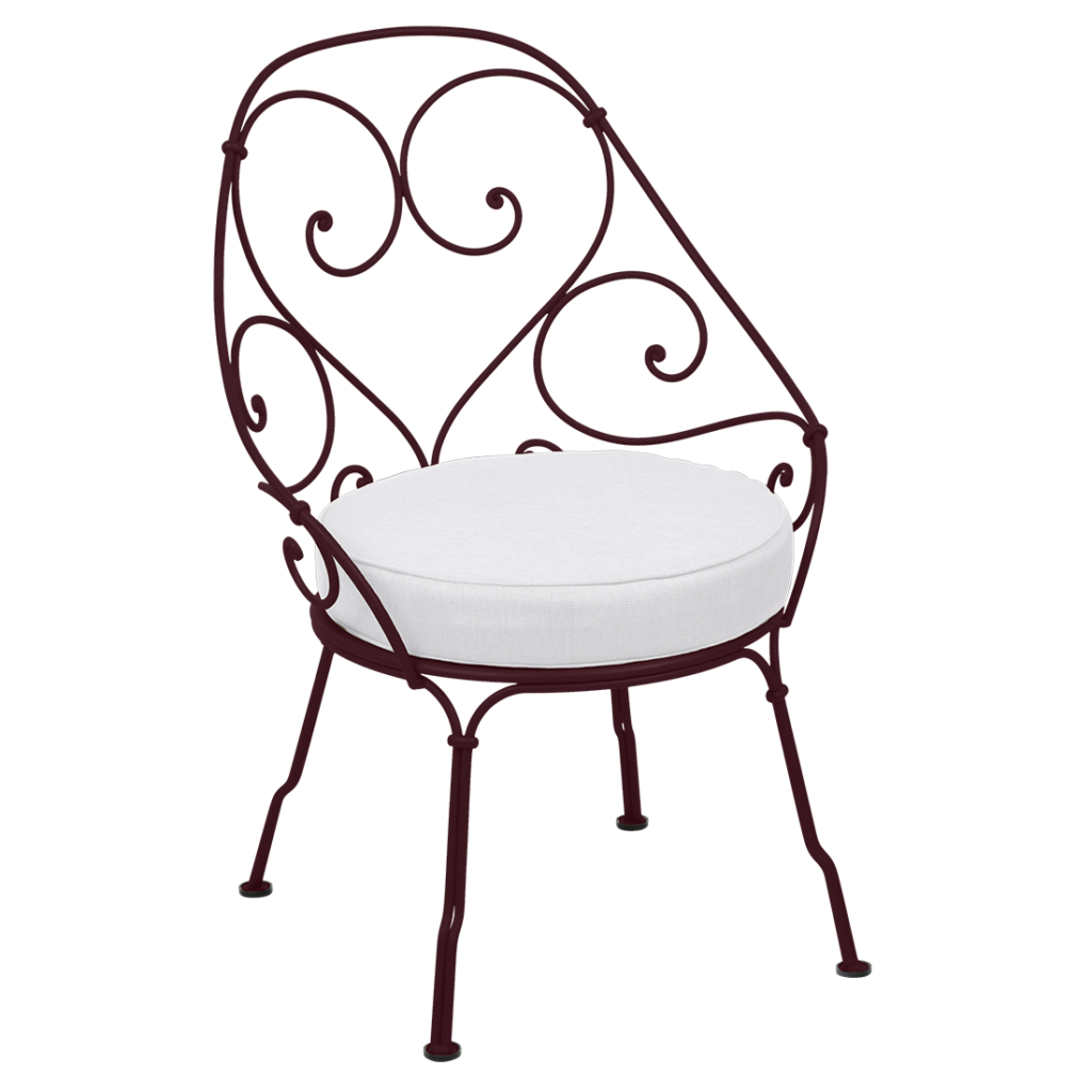 Une chaise en fer forgé avec un coussin blanc.