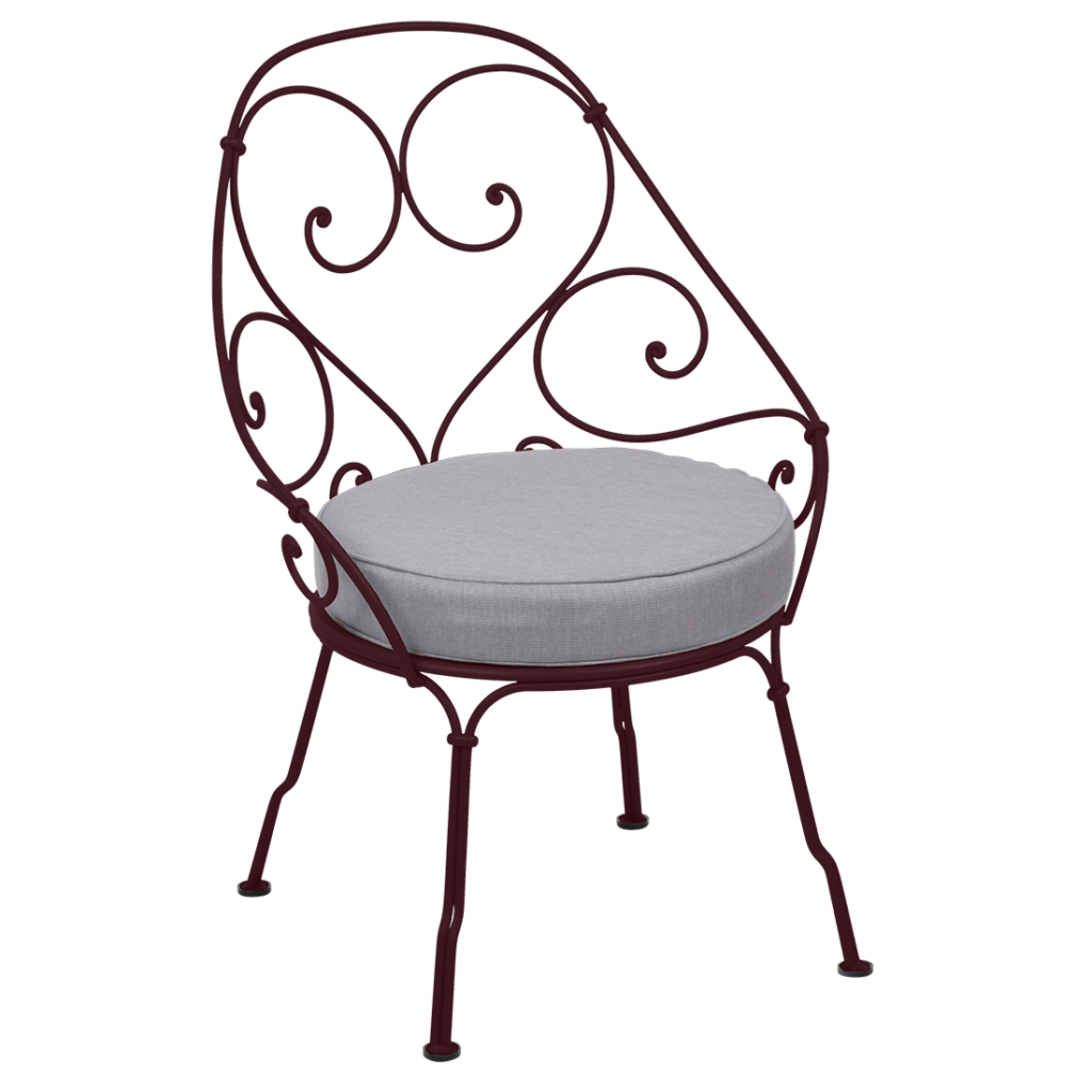 Une chaise en fer forgé avec un coussin.