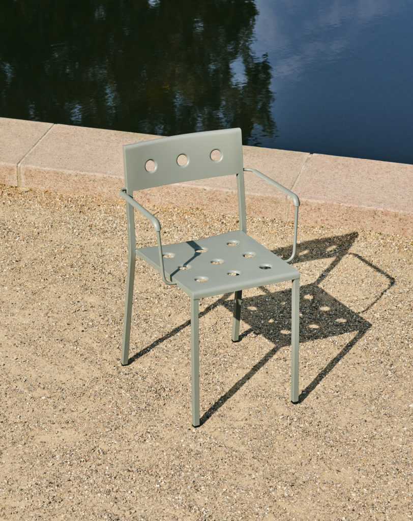 Un Fauteuils Balcon est posé au sol à côté d'un étang.