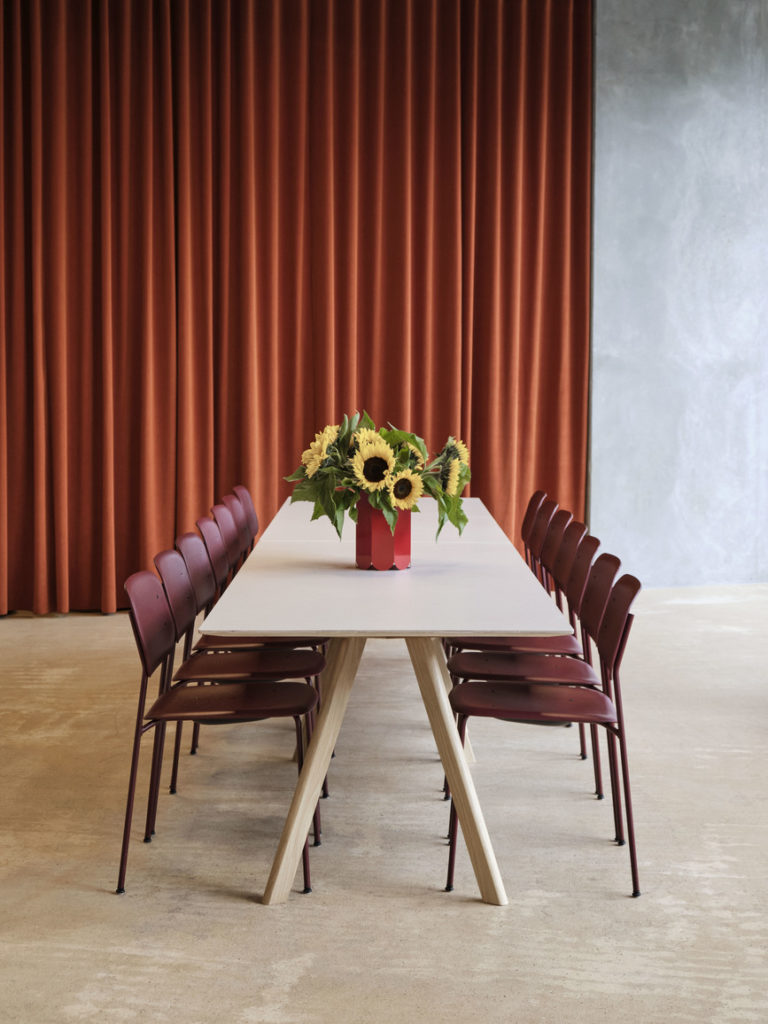 Une table CPH 30 et des chaises dans une pièce avec un rideau rouge.