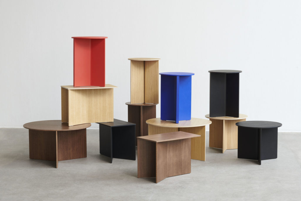 Un groupe de Table d’appoint ronde en bois fendu de différentes couleurs dans une pièce.