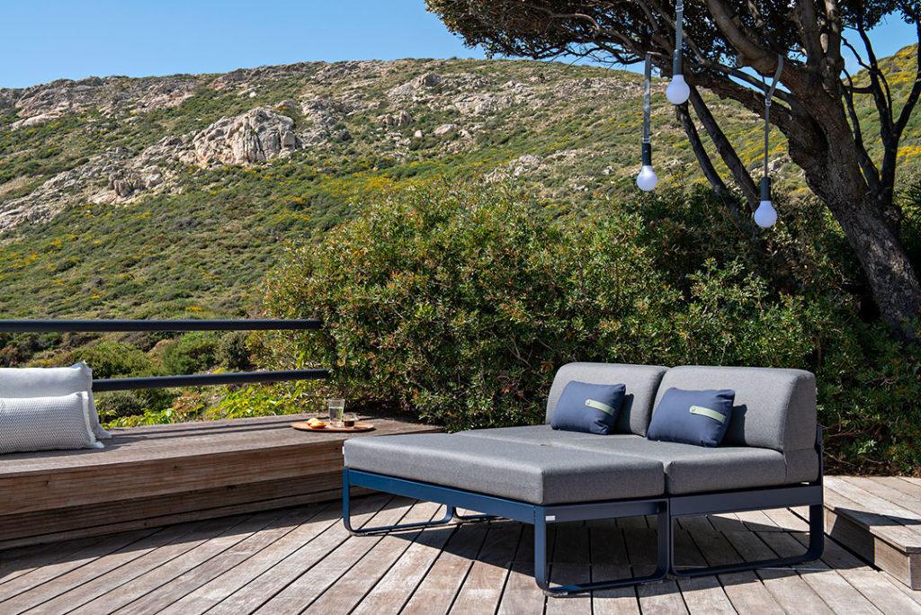 canapé 2 places avec banquettes 2 places sur une terrasse en bois avec vue montagneuse et ensoleillé