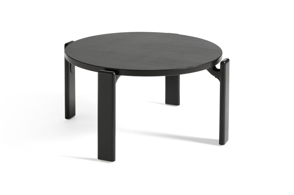 La Table basse Rey est une table ronde noire dotée de quatre pieds robustes, élégamment disposés sur un fond blanc.