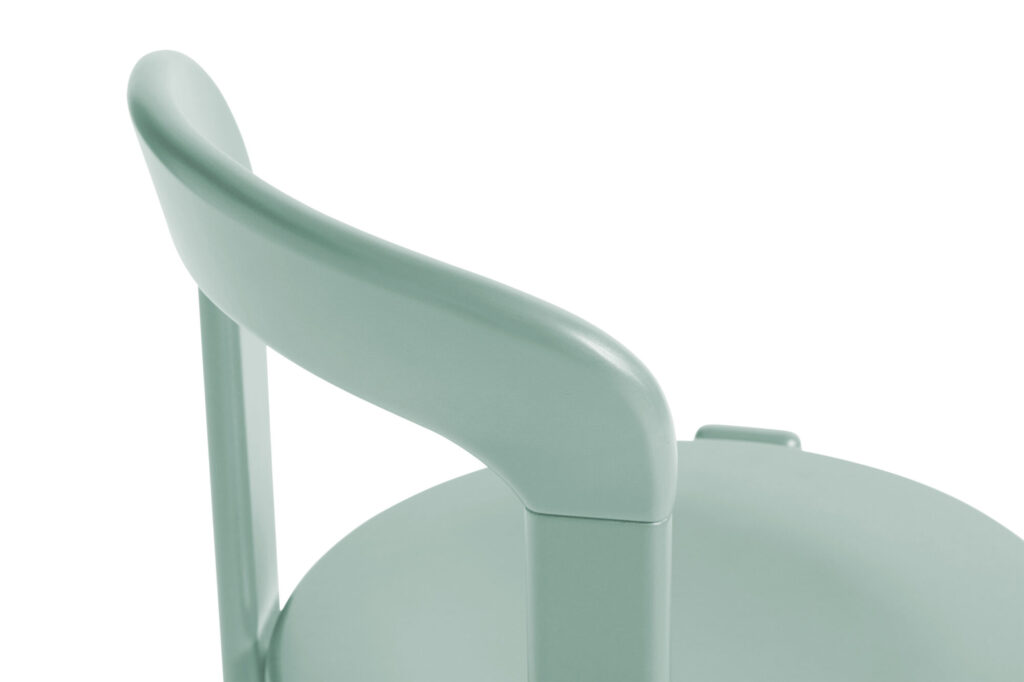 Gros plan d'une chaise Rey vert menthe avec une assise ronde et un dossier incurvé, offrant une touche d'élégance bleu profond.