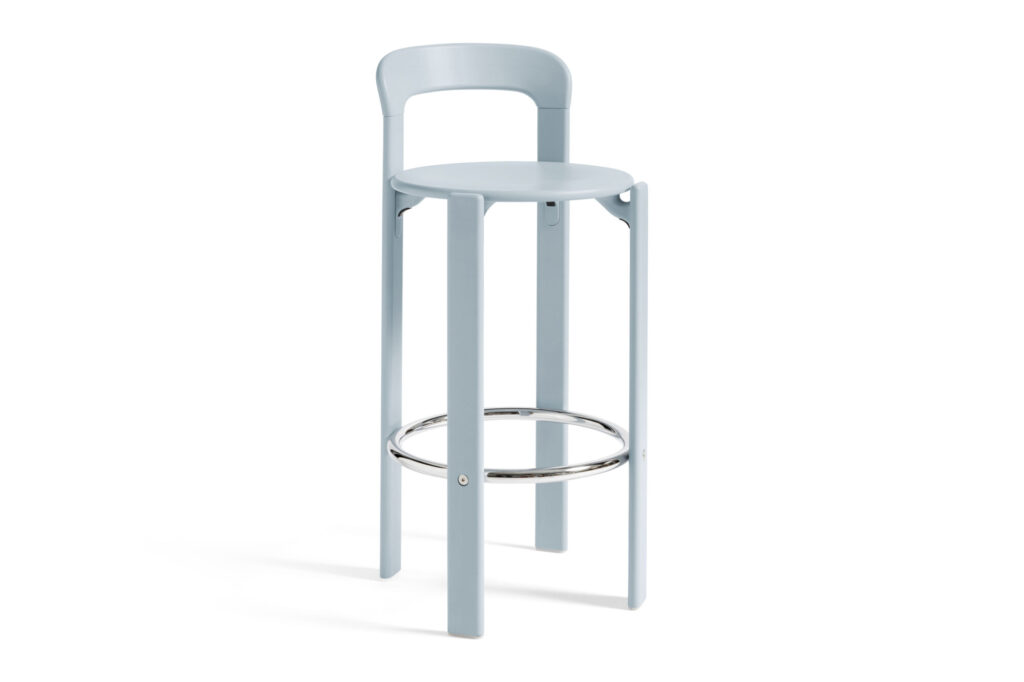 Tabouret haut bleu clair avec une assise ronde, un dossier bas et un repose-pieds circulaire en métal.