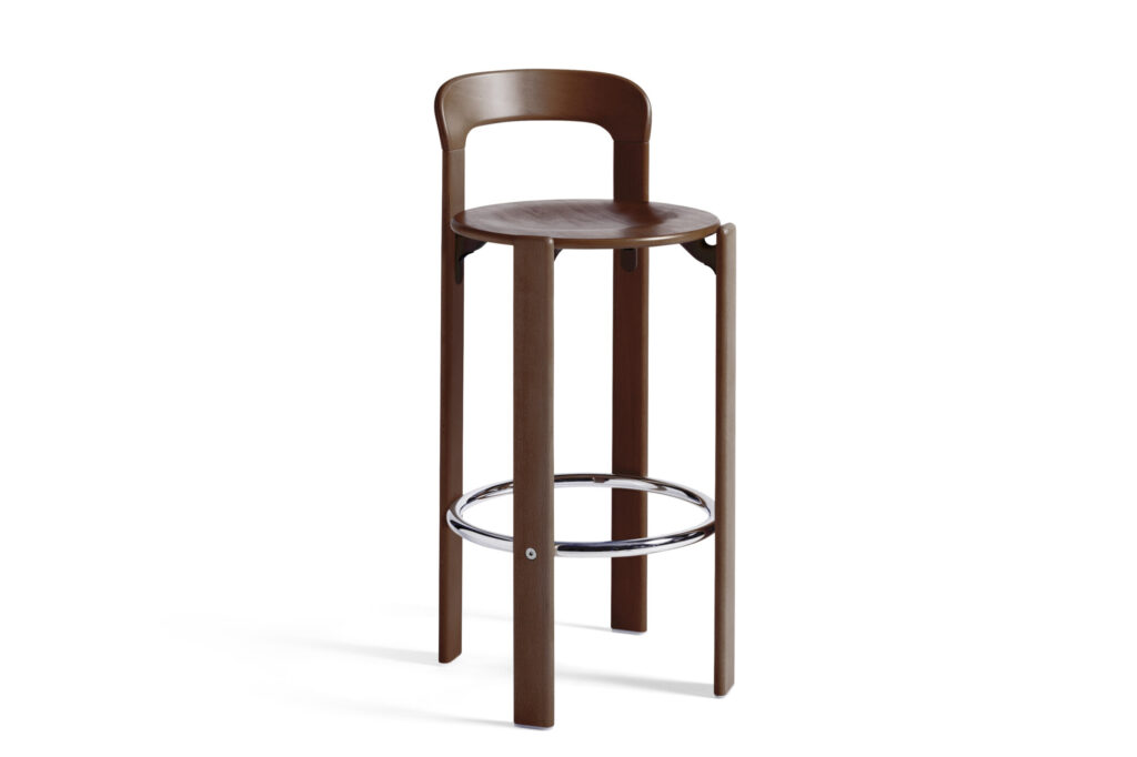 Un tabouret de bar en bois rouge écarlate avec un siège rond, un dossier incurvé et un anneau de repose-pieds chromé se détache élégamment sur le fond blanc.