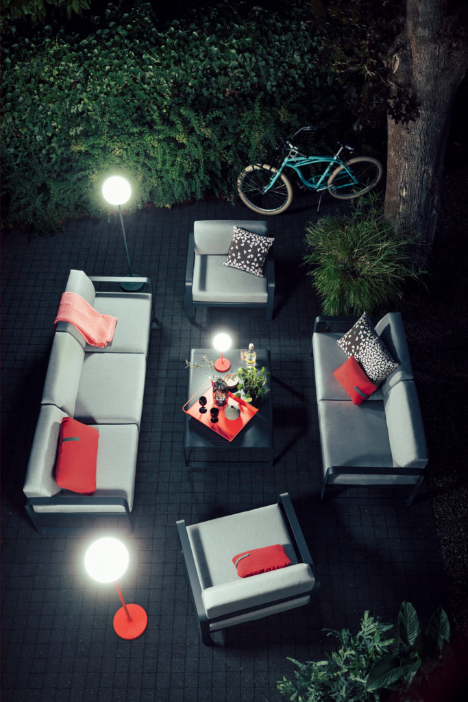 Salon Bellevie en fin de journée avec table basse, fauteuil et canapé 3 places, ambiance nocturne