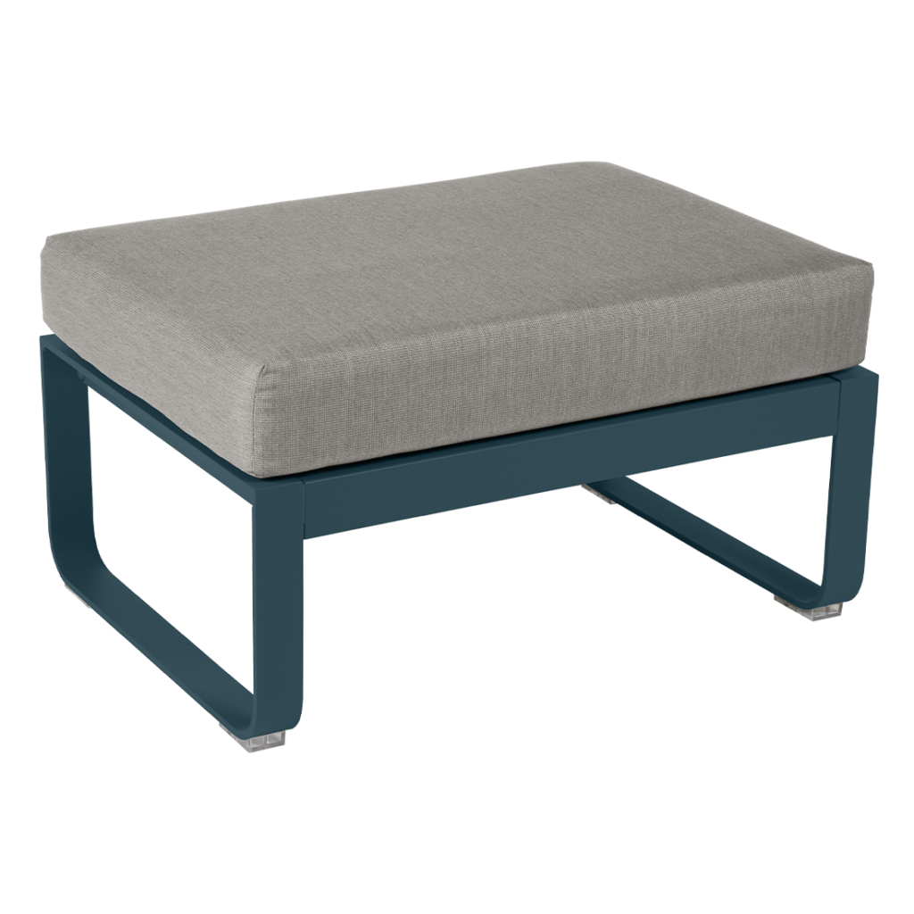 Un pouf gris avec un coussin bleu.