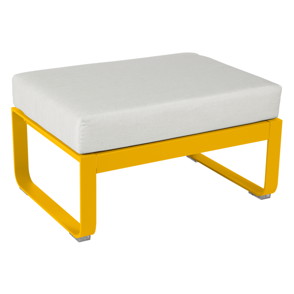 Un pouf jaune avec un coussin blanc.