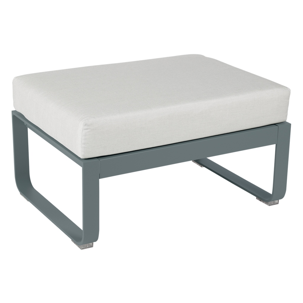 Un pouf gris avec un coussin blanc.