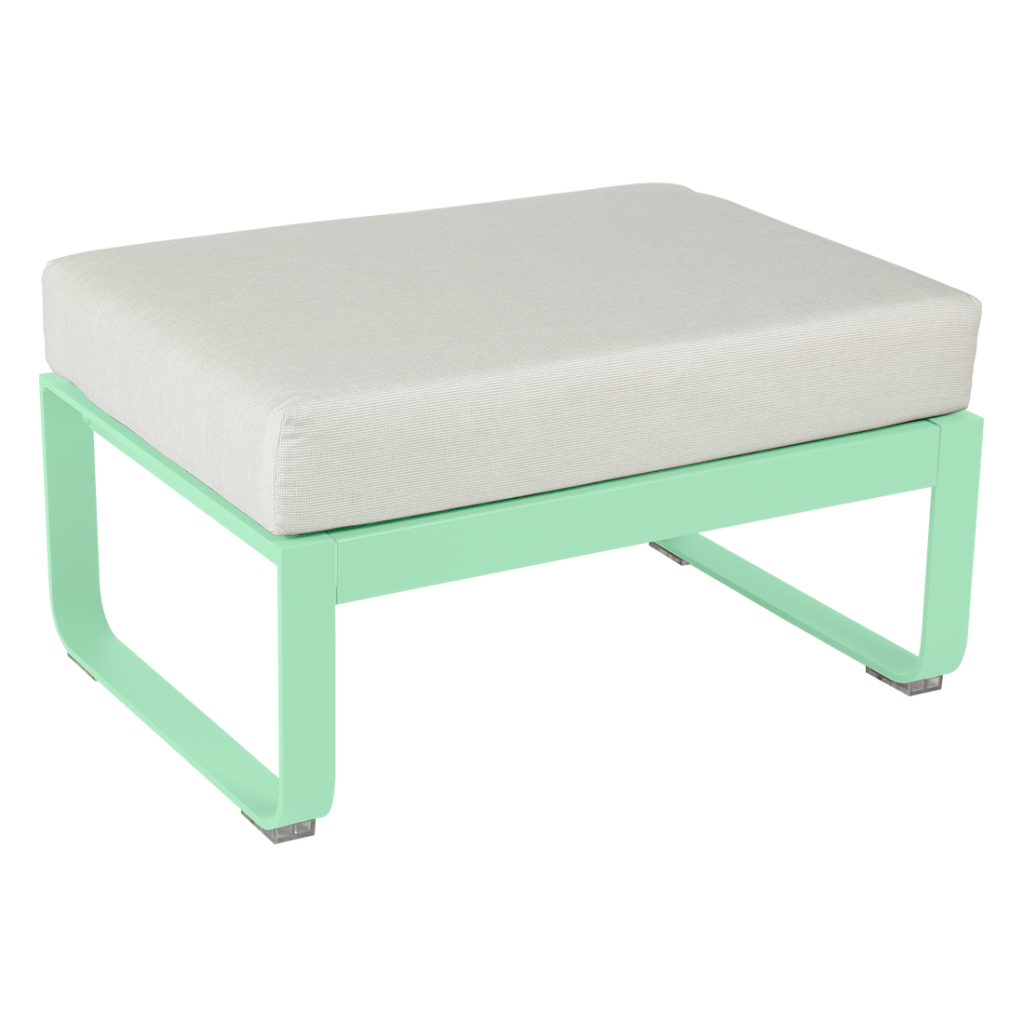 Un pouf vert menthe avec un coussin blanc.