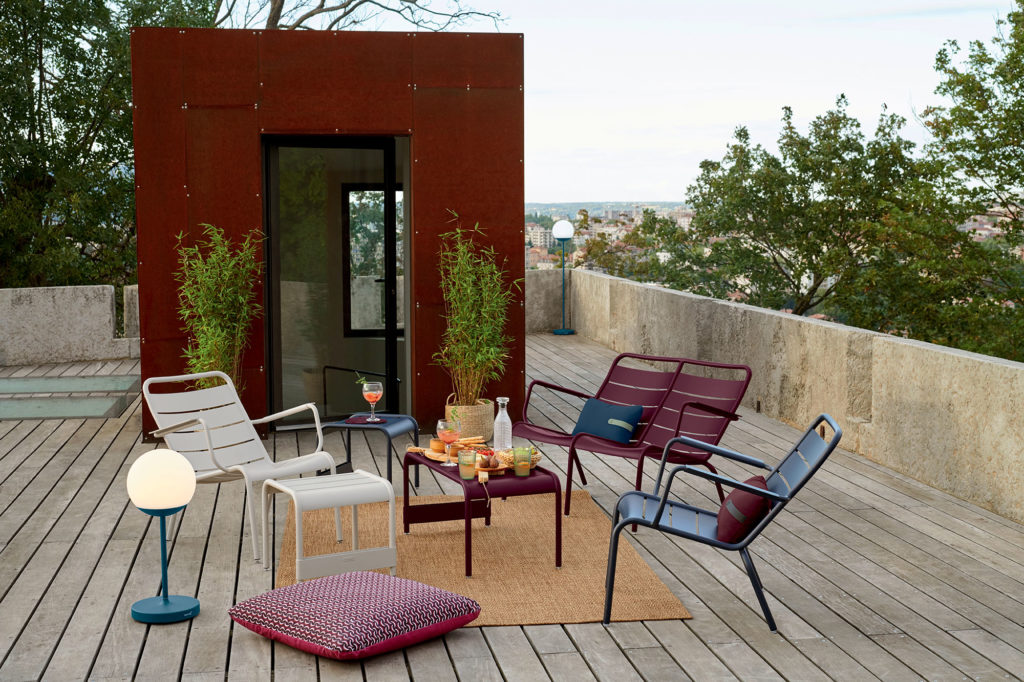 Ensemble de chaise Luxembourg sur un rooftop entouré de plantes surplombant une ville ensoleillée