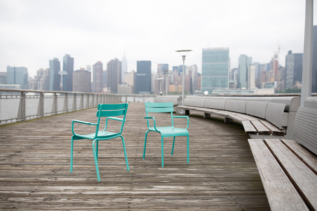 Chaise avec accoudoir Luxembourg sur un pont en bois en plein New York avec un panorama sur la ville