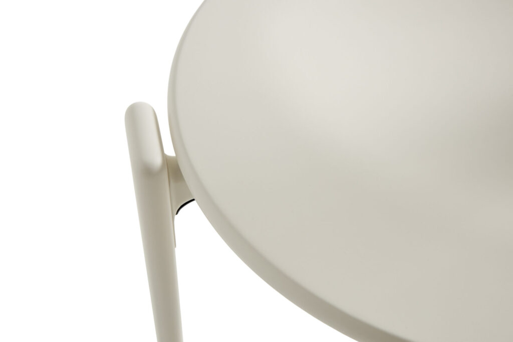 Vue rapprochée de la Chaise Rey, un siège beige, rond, avec une surface lisse et une poignée ou un support cylindrique, sur fond blanc.