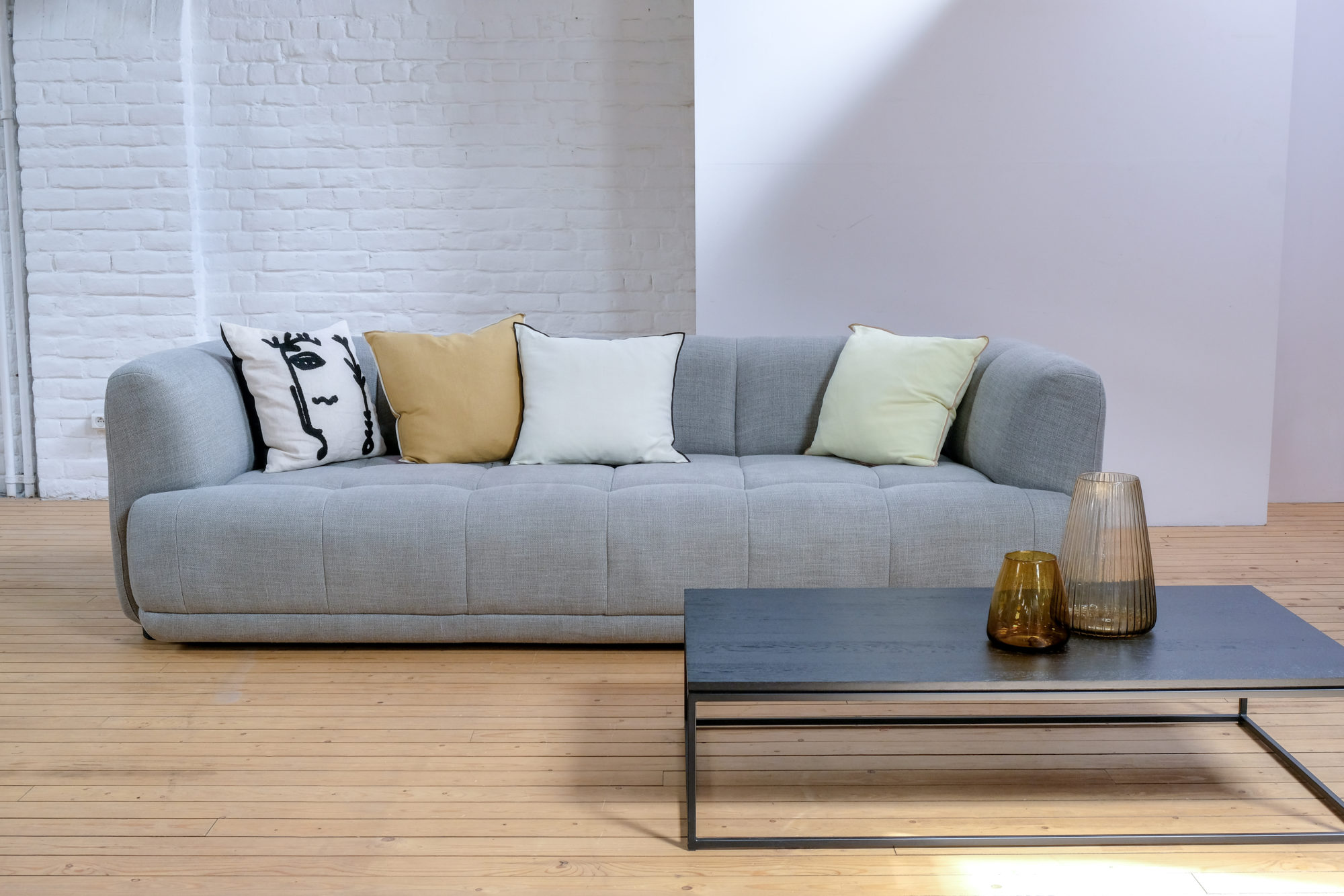 Un salon avec un canapé gris et une table basse.